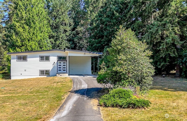 view of front of home with a front yard and a carport