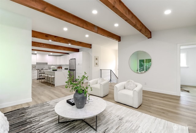 living room with beamed ceiling and light hardwood / wood-style floors