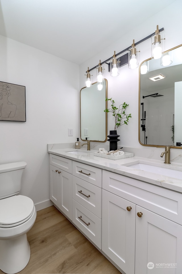 bathroom featuring a shower, hardwood / wood-style floors, vanity, and toilet