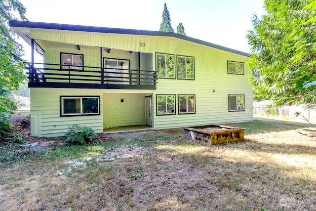 rear view of property with a lawn and a balcony