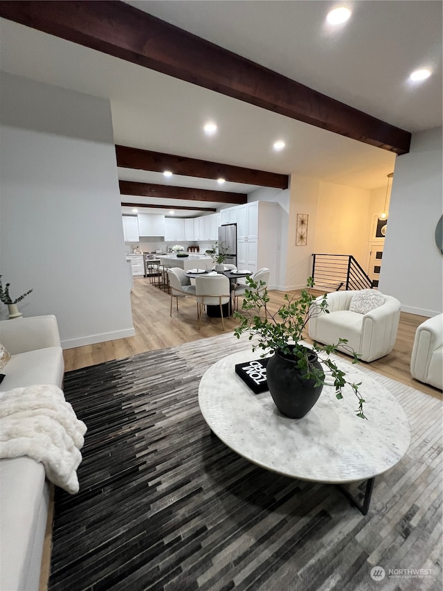 living room with beamed ceiling and wood-type flooring