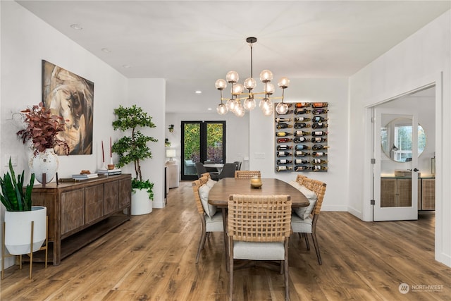 dining area with french doors, hardwood / wood-style flooring, and a notable chandelier