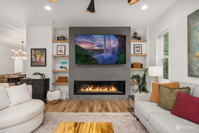 living room with a fireplace, hardwood / wood-style floors, and a chandelier