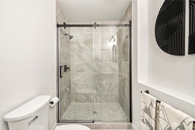 bathroom featuring toilet and an enclosed shower