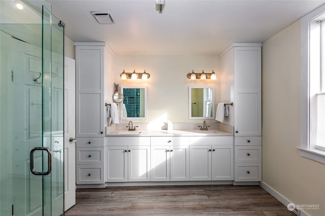 bathroom with a shower with door, vanity, and hardwood / wood-style flooring