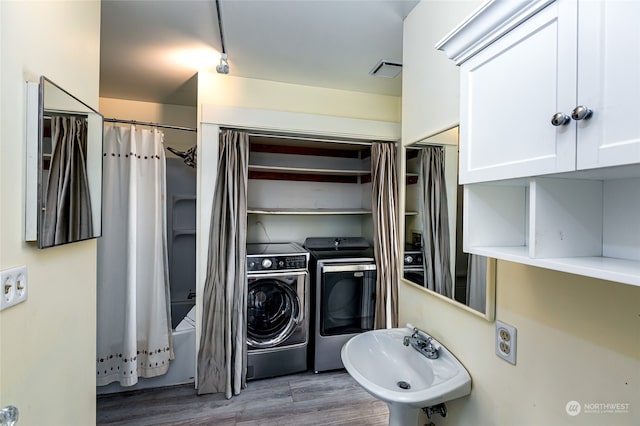 laundry area featuring hardwood / wood-style floors, washer and dryer, and sink