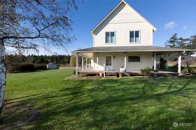 back of property with a lawn, covered porch, and a storage unit