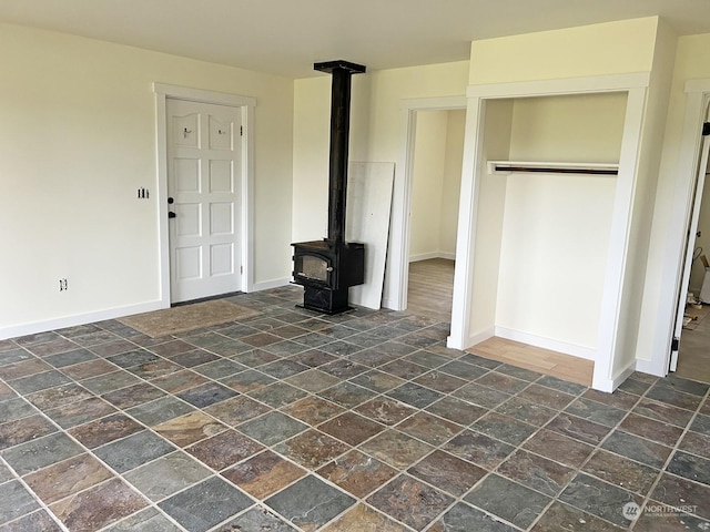 unfurnished living room with a wood stove