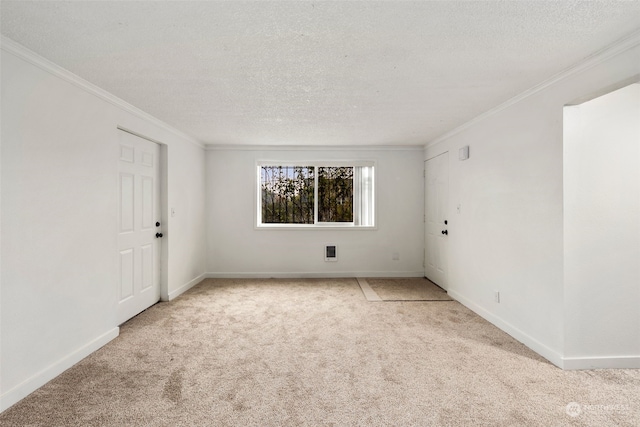 carpeted spare room with a textured ceiling and ornamental molding