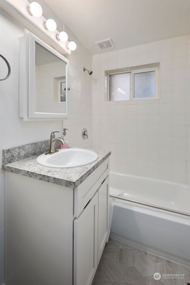 bathroom featuring vanity and tiled shower / bath combo