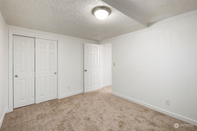 unfurnished bedroom featuring a closet, light colored carpet, and a textured ceiling