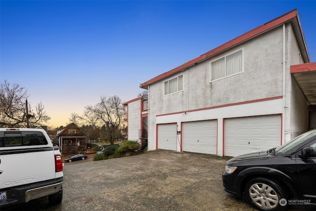 property exterior at dusk featuring a garage