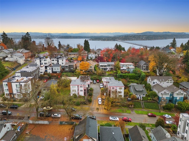 aerial view at dusk featuring a water view