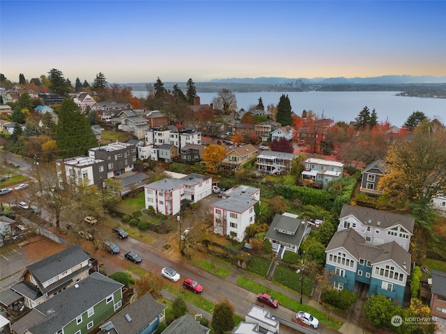 aerial view at dusk featuring a water view