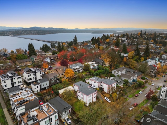 aerial view at dusk featuring a water view