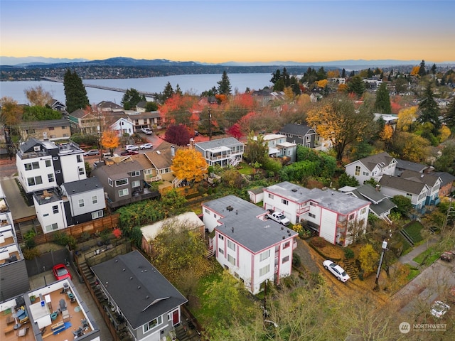 aerial view at dusk featuring a water view