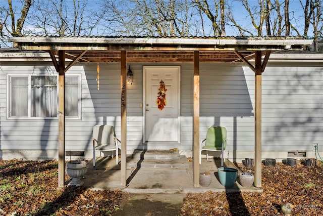 view of exterior entry with a patio area