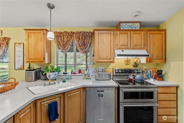 kitchen with decorative light fixtures, sink, and stainless steel appliances