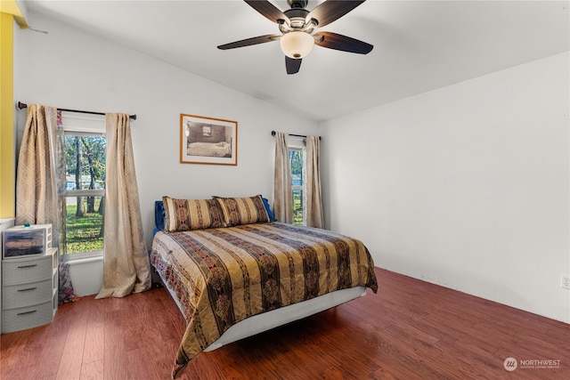 bedroom featuring dark hardwood / wood-style floors, vaulted ceiling, and ceiling fan