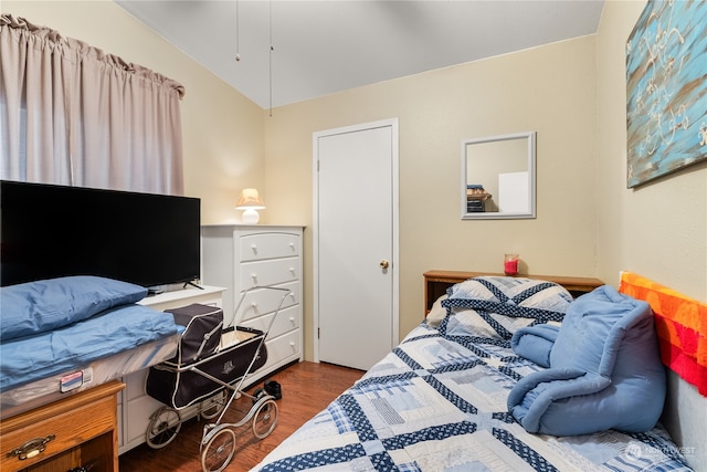 bedroom with dark wood-type flooring and vaulted ceiling