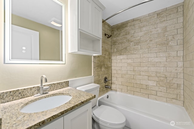 full bathroom featuring tiled shower / bath combo, toilet, and vanity