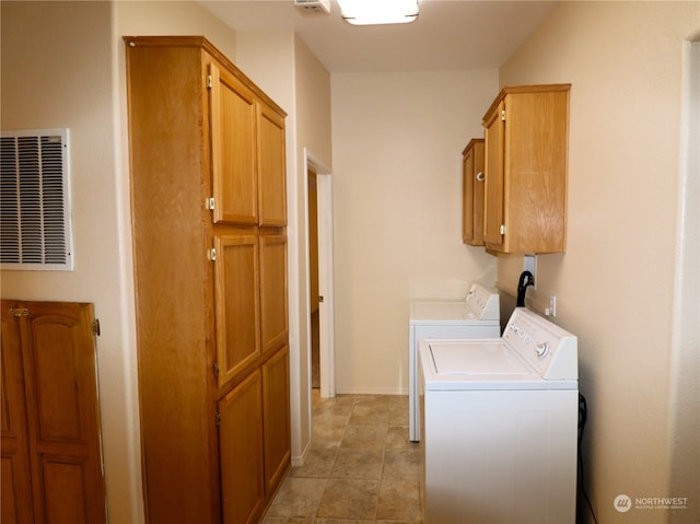 laundry area with washing machine and dryer, cabinets, and light tile patterned floors