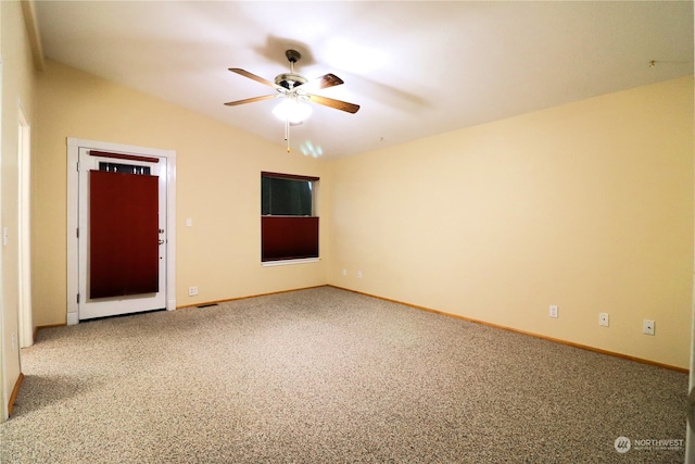 empty room featuring vaulted ceiling, carpet flooring, and ceiling fan