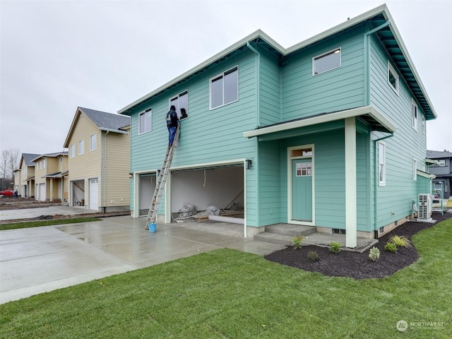 view of front of property featuring a garage, central air condition unit, and a front yard