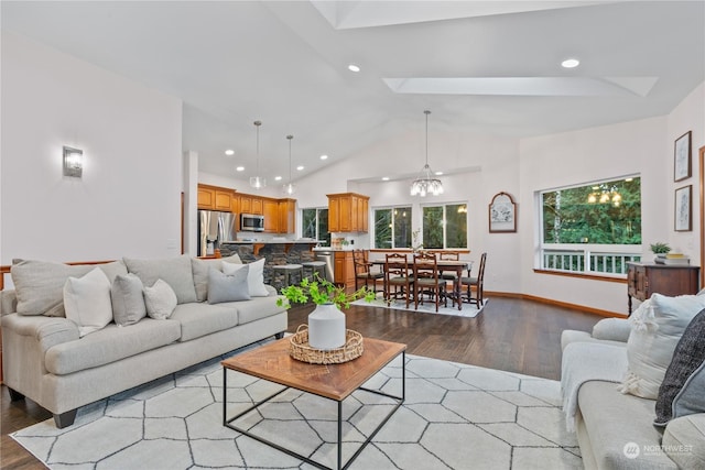 living room with high vaulted ceiling, a skylight, light hardwood / wood-style flooring, and a notable chandelier