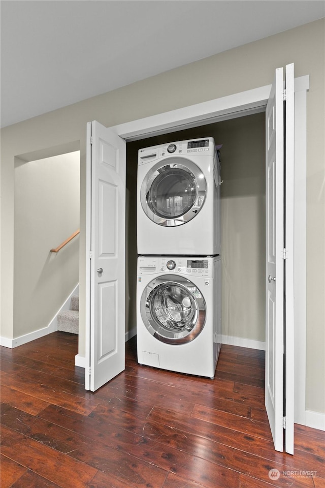 laundry area featuring dark hardwood / wood-style flooring and stacked washer / dryer