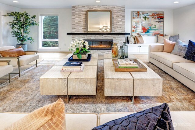 living room featuring hardwood / wood-style flooring and a stone fireplace