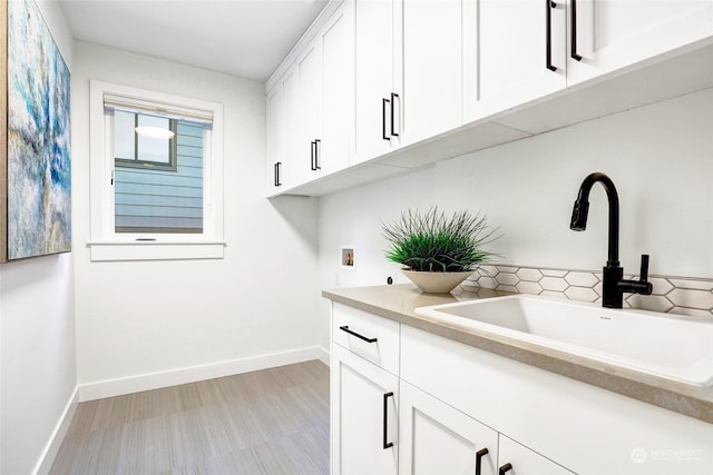 laundry room with cabinets, sink, and washer hookup