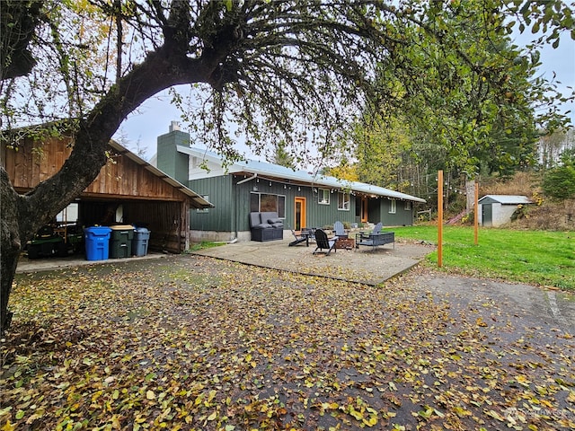 back of property featuring a patio area, a yard, and a shed