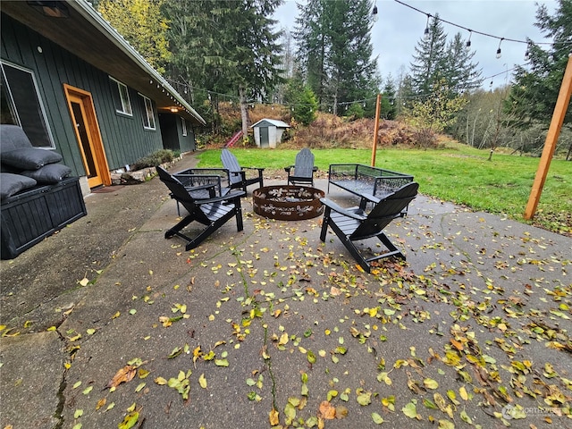 view of patio / terrace with a fire pit and a storage unit