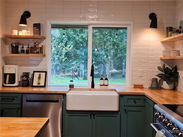 kitchen featuring sink, stainless steel appliances, wood counters, green cabinets, and backsplash