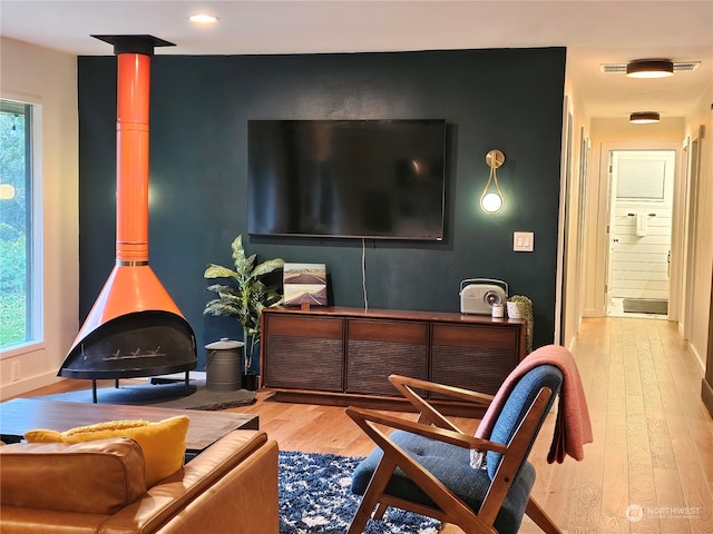 sitting room featuring hardwood / wood-style floors and a wood stove