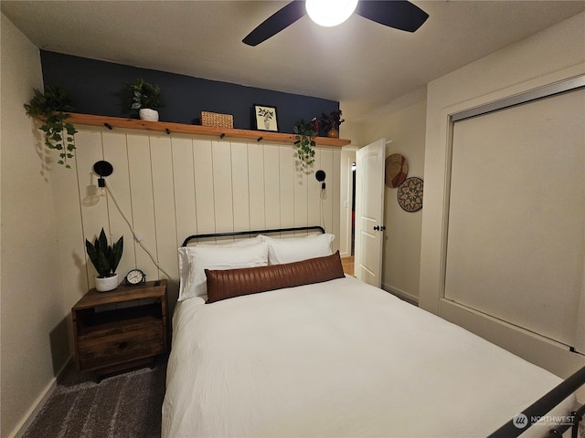 bedroom with ceiling fan, a closet, and dark colored carpet