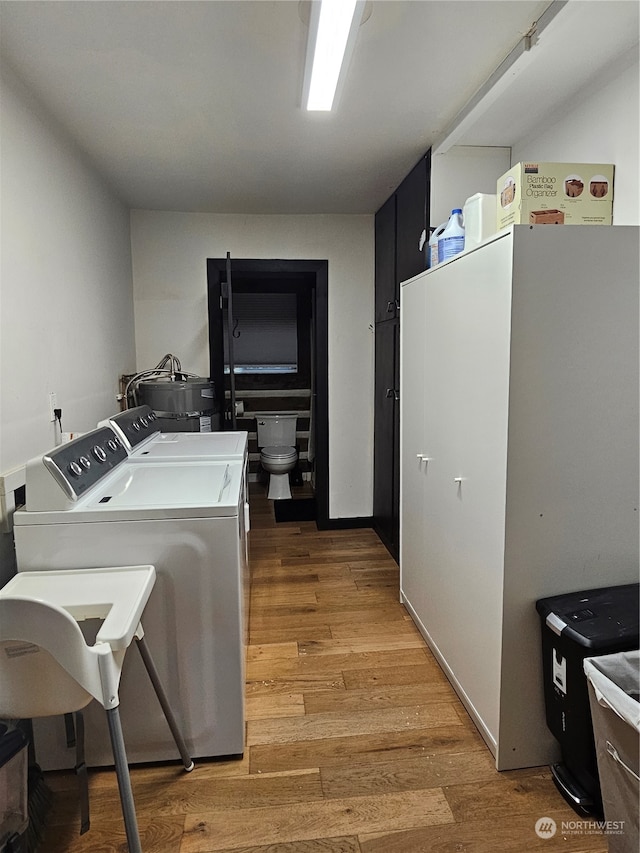 clothes washing area featuring light hardwood / wood-style floors and independent washer and dryer