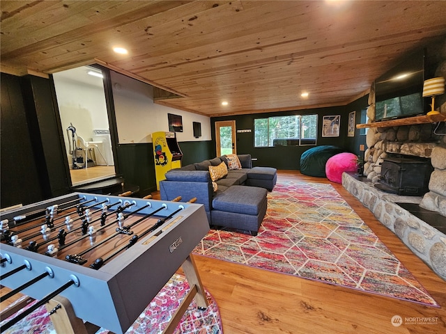 interior space with hardwood / wood-style floors, a stone fireplace, washer / dryer, and wood ceiling