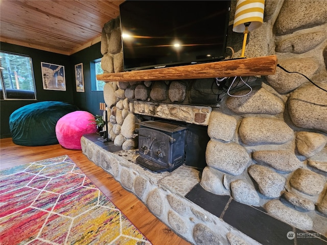 living room featuring a wood stove, hardwood / wood-style floors, and wood ceiling