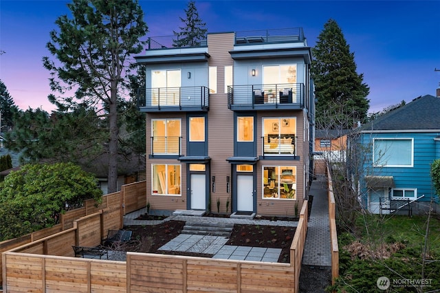 back of property with a balcony and fence private yard