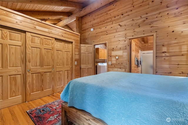 bedroom with light hardwood / wood-style flooring, wooden walls, washer / dryer, lofted ceiling with beams, and wood ceiling