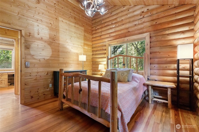 bedroom with multiple windows, high vaulted ceiling, a chandelier, and light wood-type flooring