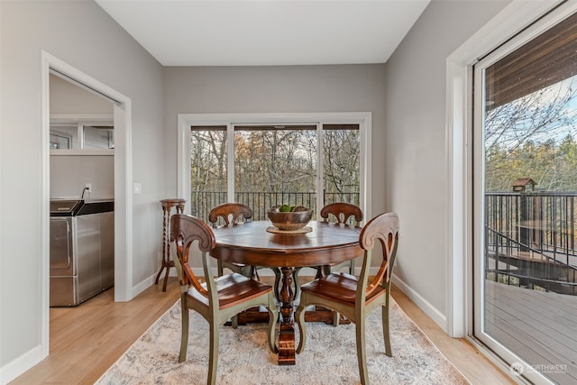 dining area featuring washer / dryer and light hardwood / wood-style flooring