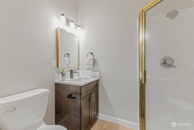 bathroom featuring vanity, toilet, wood-type flooring, and a shower