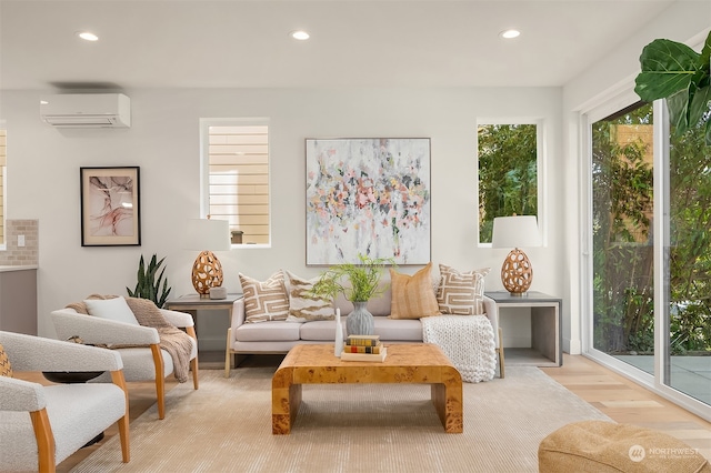 living area featuring light wood-type flooring and an AC wall unit