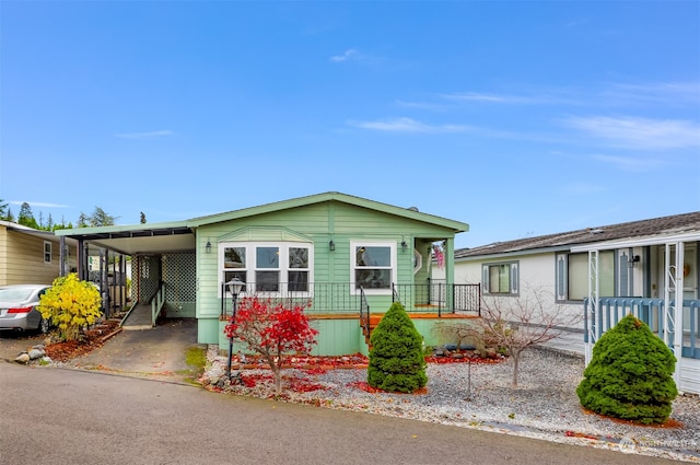 manufactured / mobile home featuring covered porch and a carport