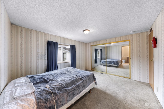 carpeted bedroom featuring a closet and a textured ceiling