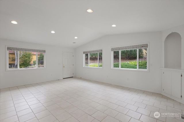 tiled spare room with vaulted ceiling and plenty of natural light