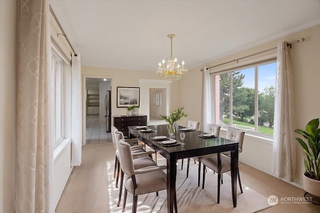 tiled dining room featuring ornamental molding and an inviting chandelier